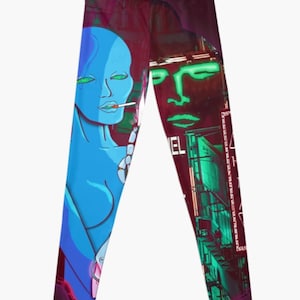May include: A pair of leggings with a colorful graphic design featuring a blue woman with green eyes and a cigarette, and a green face on a red background with the word "Chanel" visible.