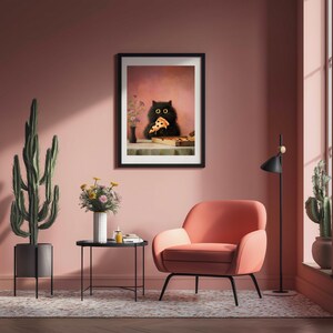Puede incluir: Una impresi&oacute;n art&iacute;stica enmarcada representa a un gato negro comiendo pizza. El gato tiene grandes ojos amarillos y sostiene una porci&oacute;n de pizza. El fondo es rosa suave y la impresi&oacute;n est&aacute; en un marco negro.