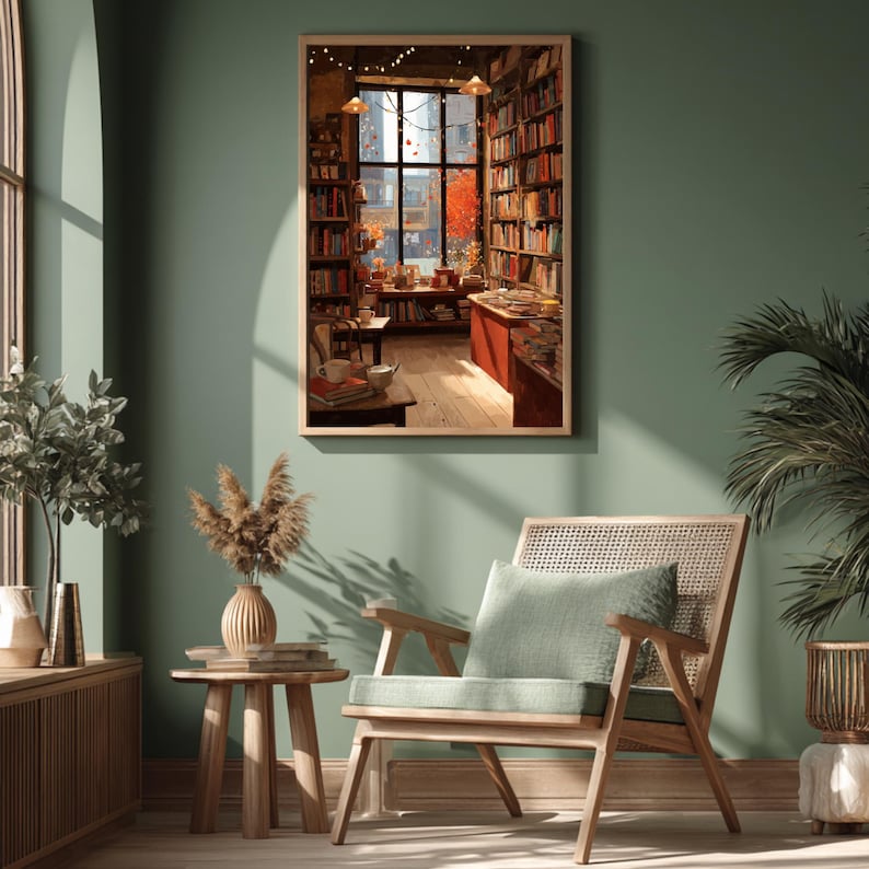 A framed illustration of a bookstore with autumn trees outside the window, centered on a dark green wall above a wooden chair and plant.