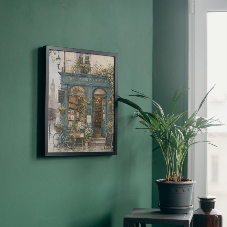A framed print of "The London Book Nook" hangs on a dark green wall, with a potted plant on a small table to the right.