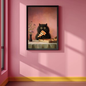Puede incluir: Impresi&oacute;n art&iacute;stica enmarcada que representa a un gato negro comiendo una porci&oacute;n de pizza. El gato tiene grandes ojos amarillos y est&aacute; sentado en una mesa con una caja de pizza. Un jarr&oacute;n con flores tambi&eacute;n est&aacute; sobre la mesa. El fondo es rosa suave.