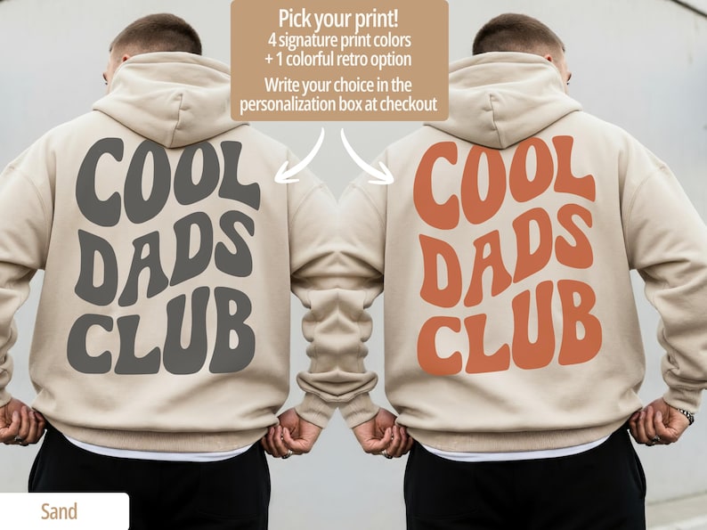May include: Two beige hoodies with the text "COOL DADS CLUB" in gray and orange. The image includes text that says "Pick your print! 4 signature print colors + 1 colorful retro option. Write your choice in the personalization box at checkout."