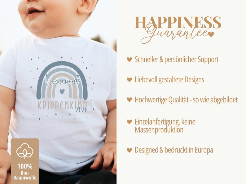 May include: A white short-sleeved t-shirt featuring a graphic of a muted blue and beige rainbow with the text Leonard, KRIPPENKIND, and 2026. The shirt includes a small heart icon and scattered dots. A label indicates 100% organic cotton.