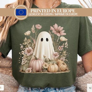 Op de afbeelding: Militairgroen T-shirt met een illustratie van een spook en pompoenen. Het ontwerp toont een witte geest met zwarte ogen, omringd door pastelkleurige pompoenen en bloemen. De tekst "PRINTED IN EUROPE" is weergegeven.