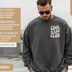 May include: Dark heather gray sweatshirt with the text "COOL DADS CLUB" in a white, retro font. The sweatshirt is made of a soft material. The image also includes the text "super soft".