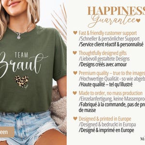 Pu&ograve; includere: T-shirt verde oliva con la scritta "Team Braut" in corsivo bianco, un cuore con stampa leopardata e le parole "Military Green" in basso. La maglietta fa parte di una collezione sposa.