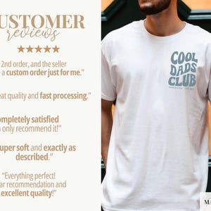 May include: White t-shirt with a light blue "Cool Dads Club" graphic on the chest. The shirt also features the text "Born & Lunch" and "Est. 2022". The image includes customer reviews.