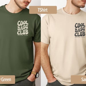 May include: Two t-shirts, one military green and one sand-colored, each featuring the text "COOL DADS CLUB" in a retro font. The shirts have a crew neck and short sleeves. The text "NOAH & LENA EST. 2022" is below the main text.