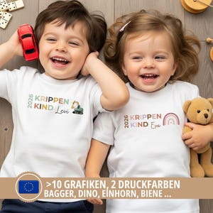 May include: Two white short-sleeved t-shirts featuring the text 2026 KRIPPEN KIND with personalized names Levi and Eva. One shirt displays a small excavator graphic, while the other features a rainbow graphic in muted earth tones.