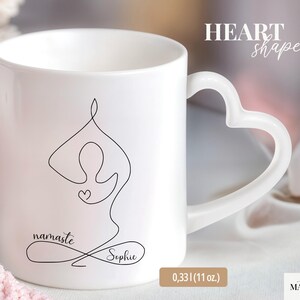 May include: White ceramic mug with a heart-shaped handle. The mug features a black line drawing of a yoga pose, the word "namaste", and the name "Sophie". The mug holds 11 oz.