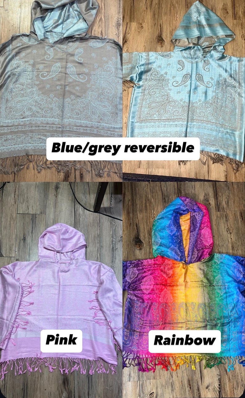 May include: Four hooded shawls in the image. The top left is blue/grey reversible, the top right is light blue, the bottom left is pink, and the bottom right is rainbow-colored. Each shawl has a paisley design and fringe.