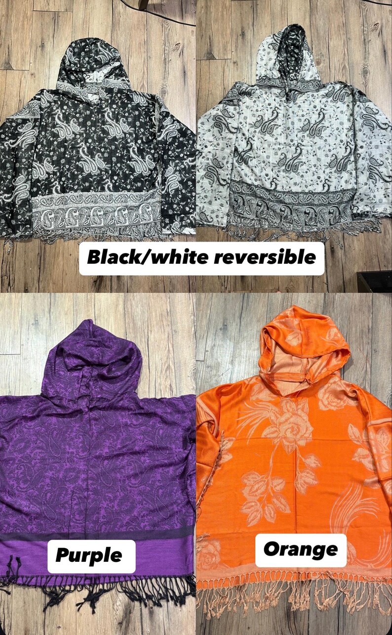 May include: Four hooded reversible jackets in black/white, purple, and orange. The black and white jackets have a paisley pattern. The purple jacket has a paisley pattern, and the orange jacket has a floral design. Each jacket has a fringed hem.