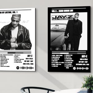 Könnte beinhalten: Zwei schwarz-weiß gerahmte Poster mit Jay-Z-Albumcovern. Das linke Poster zeigt "In My Lifetime, Vol. 1" und das rechte Poster "Vol. 2... Hard Knock Life". Beide Poster enthalten Titellisten, Albumdetails und den Namen des Künstlers.
