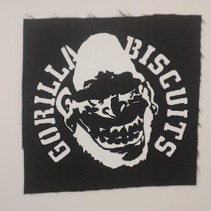 May include: Black square patch with white text and a gorilla face graphic. The text reads "GORILLA BISCUITS" in a circular arrangement around the gorilla's face. The gorilla graphic is a stylized, grinning face.