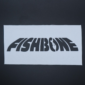 K&ouml;nnte beinhalten: Ein wei&szlig;es rechteckiges Patch mit dem Wort "FISHBONE" in fetten, schwarzen, stilisierten Buchstaben. Der Buchstabe "O" wird durch eine Fischskelettgrafik ersetzt. Das Patch befindet sich vor einem schwarzen Hintergrund.