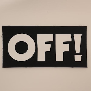 May include: A black rectangular patch with the word "OFF!" in bold white letters. The exclamation point is included. The patch is made of a textured fabric.