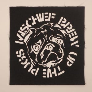 May include: Black square patch featuring a white illustration of a pug's face surrounded by text. The text reads "THE FIVE PUGS ARE REALLY UP TO MISCHIEF". The patch has a textured appearance.
