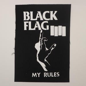 May include: Black and white patch with the text "Black Flag" and "My Rules". A stylized hand with the middle finger extended is shown below the text.