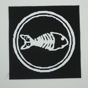 Puede incluir: Un parche cuadrado negro con un dise&ntilde;o de esqueleto de pez blanco dentro de un borde circular blanco. El esqueleto del pez est&aacute; estilizado, con costillas, cabeza y cola visibles. El parche es probablemente para ropa o accesorios.