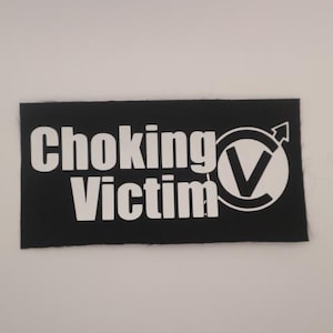 May include: Black patch with white text that reads "Choking Victim" and a white check mark symbol inside a circle.
