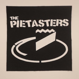 May include: Black and white patch with the text "The Pietasters" and a stylized image of a pie on a plate.