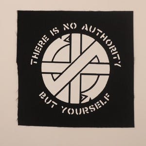 May include: Black and white patch with a circle and the text "There is no authority but yourself."