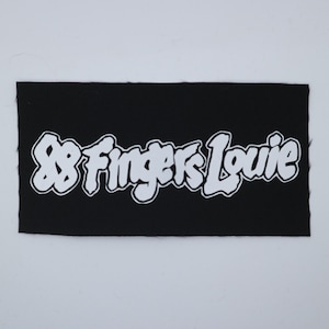 May include: A black rectangular patch with the white text "88 Fingers Louie" in a stylized font. The text has a white outline. The patch is likely for clothing or accessories.