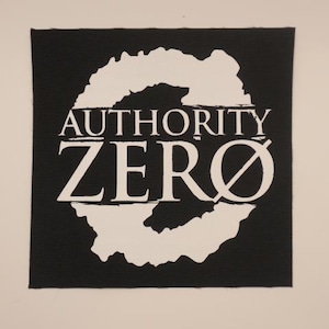 May include: Black and white embroidered patch with the text "AUTHORITY ZERO" in a white circle with a slash through the zero.