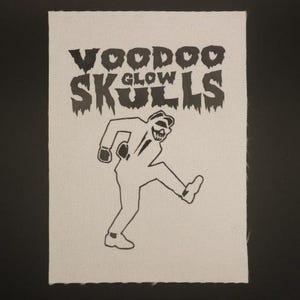 May include: A white patch with black text that reads "Voodoo Glow Skulls" and a black silhouette of a person dancing.
