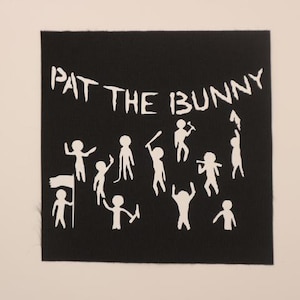 May include: Black fabric patch with white text that reads "Pat the Bunny" and white stick figure illustrations.