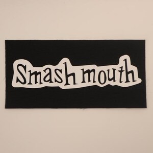May include: Black fabric patch with white lettering that reads "Smash Mouth".