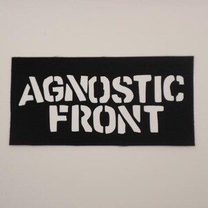 May include: Black and white patch with the text "Agnostic Front" in a stencil font.