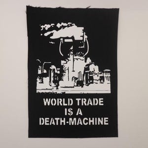 May include: Black and white patch with a graphic of a factory and the text "WORLD TRADE IS A DEATH-MACHINE".