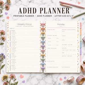 May include: An open ADHD planner with a weekly focus page on the left and a Monday daily page on the right. The planner features colorful disc binding, floral accents, and printed text including 'ADHD PLANNER' and 'LETTER SIZE 8.5" x 11"'.