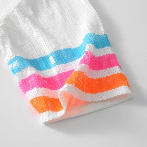 May include: White sequined fabric with colorful horizontal stripes in blue, pink, and orange. The fabric appears to be part of a garment, possibly a sleeve or trim, with a bright and playful design.
