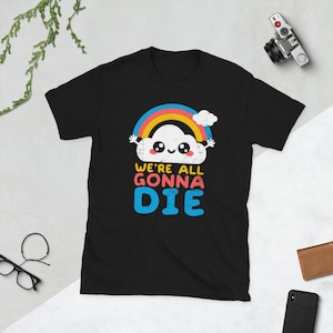 Könnte beinhalten: Schwarzes T-Shirt mit einer Cartoon-Wolke mit einem Regenbogen darüber. Der Text "We're all gonna die" befindet sich unter der Wolke.