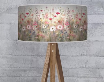 May include: A floral lampshade featuring a watercolor design of wildflowers in shades of pink, red, white, and yellow. The lampshade is cylindrical and sits on a wooden tripod lamp base.