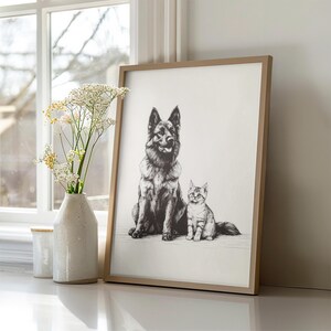 May include: A black and white drawing of a German Shepherd dog and a cat sitting side by side. The drawing is framed in a light brown wood frame and is hanging on a white wall.