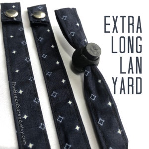 May include: Two black and white patterned fabric straps with a black plastic adjustable buckle. The straps are labeled "EXTRA LONG LANYARD".