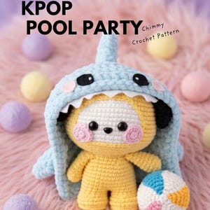 May include: An amigurumi crochet pattern ebook titled KPOP POOL PARTY Chimmy Crochet Pattern. The image features a yellow crocheted character wearing a light blue shark hood with white teeth, black eyes, and pink cheeks, holding a small colorful ball.