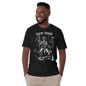 modelo posando con Camiseta de manga corta unisex de Baron Samedi color negro, una prenda única que combina magia y simbolismo espiritual en un diseño gotico para amantes del esoterismo y la magia vudu