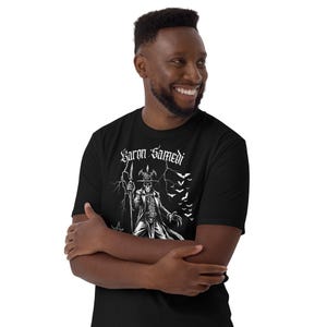 modelo posando con Camiseta de manga corta unisex de Baron Samedi color negro, una prenda única que combina magia y simbolismo espiritual en un diseño gotico para amantes del esoterismo y la magia vudu