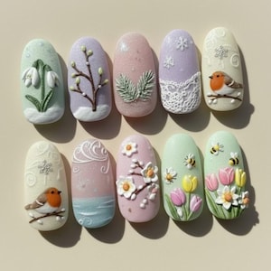 Puede incluir: Diez diseños de uñas en forma de almendra con motivos primaverales. Cada uña presenta un diseño único, como flores, pájaros, abejas y copos de nieve. Las uñas están pintadas en tonos pastel como rosa, verde y lavanda.