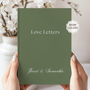 May include: A sage green hardcover book with the white text Love Letters printed in the center and the names Jared & Samantha printed in white script at the bottom. A white scalloped sticker with the text MORE COLORS is on the top right.
