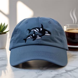 Twin Orcas Embroidered Hat – Minimalist Black and White Whale Design on Deep Blue Cap