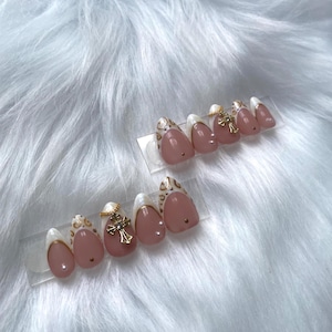 Elegantes uñas postizas con cruz dorada