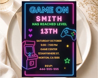 May include: A rectangular invitation card with a black background and neon-style graphics. Text reads: GAME ON SMITH HAS REACHED LEVEL 13TH, SATURDAY OCTOBER, 5:00-7:00 PM, GAME CENTER, 123ANYWHERE ST., NORTON, CA 1886, RSVP: 444-555-555. Includes arcade machine.