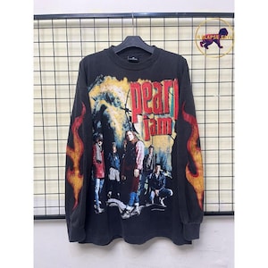 Könnte beinhalten: Schwarzes Langarmshirt mit Bandgrafik. Das Shirt hat ein Bandbild und den Namen "Pearl Jam" in roten und gelben Flammen. Die Ärmel haben Flammendesigns.