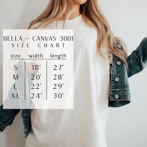 May include: A white t-shirt worn under a dark blue denim jacket, overlaid with a Bella + Canvas 3001 size chart. The chart lists sizes S, M, L, and XL with corresponding widths of 18, 20, 22, and 24 inches and lengths of 27, 28, 29, and 30 inches.