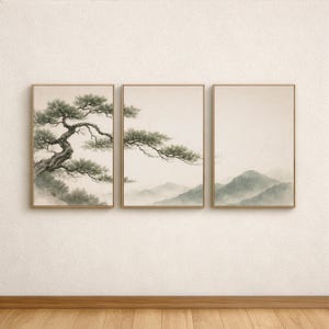 May include: A triptych of framed art prints showcasing a tranquil landscape. The prints feature a detailed tree with green leaves and a mountain range in soft, muted tones. The frames are gold, adding a touch of elegance.
